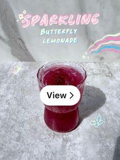 a glass filled with liquid sitting on top of a cement floor next to a wall