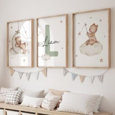 three framed pictures hang above a bench in a child's room with pillows and blankets