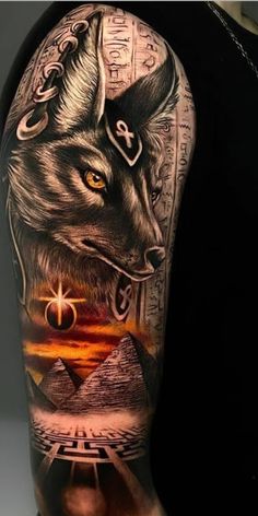 a man's arm with an image of a wolf and pyramids on it