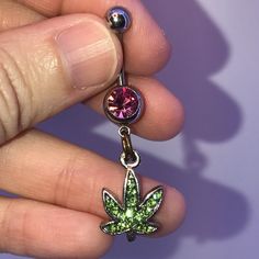 These Are 316-L Stainless Steel Belly Ring With A Dangle Of A Pot Leaf Design. The Ring In The Middle Is A Split Or Spring Ring. It's Designed This Way So Your Charm Stays On Your Belly Ring. Green Rhinestone Leaf With Medium Pink Top Gold Split Ring If You Want A Different Color Belly Ring Let Me Know I Can Change Them Out. This Is A Standard 14 Gauge Belly Ring. The Top Gem Changes From One Belly Ring To Another But The Bottom Stays The Same. It Is A Peridot Green Rhinestone Pot Leaf That Is M Adjustable Pink Jeweled Jewelry, Pink Metal Jewelry With Bling, Pink Bling Metal Jewelry, Pink Jeweled Metal Jewelry, Adjustable Pink Body Jewelry For Gift, Adjustable Nickel-free Pink Belly Rings, Cute Belly Rings Dangle, Cute Belly Rings, Dangle Belly Rings