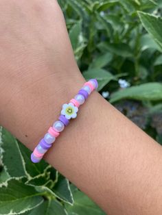 a person wearing a bracelet with flowers on it