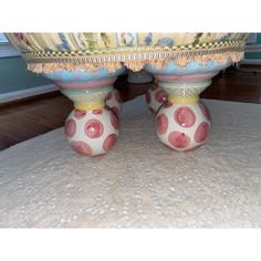 two colorful vases sitting on top of a rug