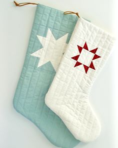 a quilted christmas stocking hanging from a string on a white tablecloth with red and white stars