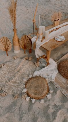 the table is set up on the beach with shells and candles in it, along with other items