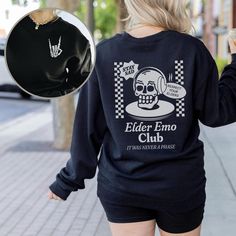 "*This shirt has a design on the FRONT & BACK* Step back in time and relive the golden era of emo music with our Elder Emo Music Sweatshirt. This comfy sweatshirt is the perfect choice for those who still carry the spirit of emo in their hearts. Featuring a captivating design of a beautifully detailed skull and a defiant \"rock on\" hand gesture, this shirt is a must-have for any elder emo enthusiast. Whether you're searching for an emo gift or wanting to express your undying love for the emo subculture, this scene shirt is the ultimate statement piece. Wear it proudly to the When We Were Young Festival or any other music event, and let the world know that your emo spirit is alive and thriving. It's not just a phase; it's a way of life. Embrace the everlasting emo culture with our Elder Em Black Letter Print Sweatshirt For Concert, Punk Letter Print Sweatshirt For Concert, Punk Style Letter Print Sweatshirt For Concert, Grunge Letter Print Sweatshirt For Concert, Punk Sweatshirt With Letter Print And Crew Neck, School Band Merch Tops With Graphic Print, Band Merch Graphic Print Top For School, School Crew Neck Sweatshirt With Graphic Print, Retro Black Top For School