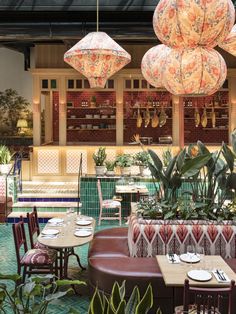 the interior of a restaurant with tables, chairs and umbrellas hanging from the ceiling