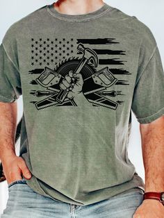 a man wearing a t - shirt with an american flag and crossed wrenches on it