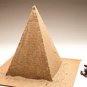 a model of a pyramid with a toy motorcycle next to it