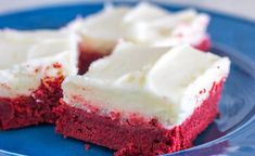 red velvet cake with white frosting sitting on a blue plate, ready to be eaten