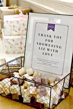 a basket filled with marshmallows sitting on top of a table next to a sign that says thank you for showering