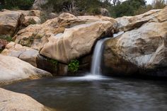 there is a small waterfall coming out of the rocks