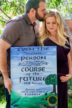 a man and woman kissing while holding a sign