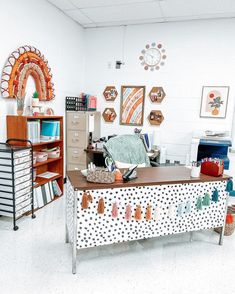 a room with many different items on the table and in front of it is a clock