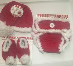 three pieces of red and white crocheted santa claus hat, diaper cover and booties