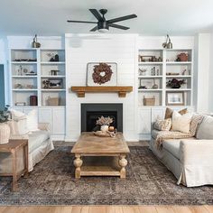 a living room filled with furniture and a fire place in front of a white fireplace