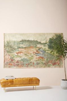 a painting hanging on the wall next to a bench with a potted plant in front of it