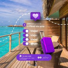 a purple suitcase sitting on top of a wooden deck next to the ocean and beach