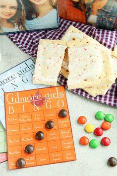 some candy is sitting on a table next to magazines and candies with the covers pulled down