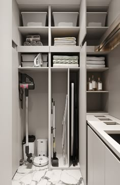 an organized walk in closet with white cabinets and marble flooring, including cleaning supplies