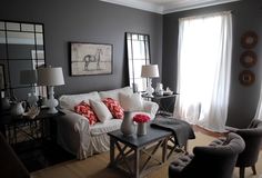 a living room filled with furniture and two lamps on either side of the couches