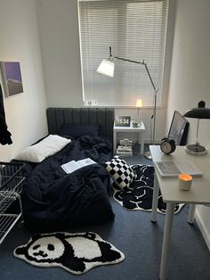 a bedroom with a bed, desk and lamp