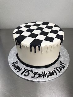 a birthday cake decorated with black and white checkers