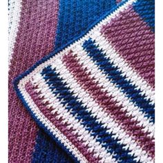 a close up view of a crocheted blanket with blue, purple and white stripes