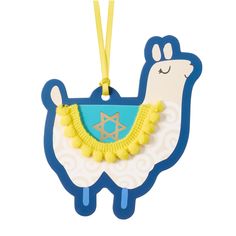 a blue and white llama shaped ornament hanging from a yellow string on a white background