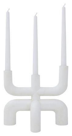 three white candles sitting on top of each other