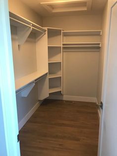 an empty closet with wooden floors and white walls