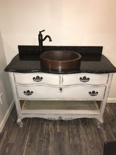 a bathroom sink sitting on top of a white vanity next to a wooden countertop