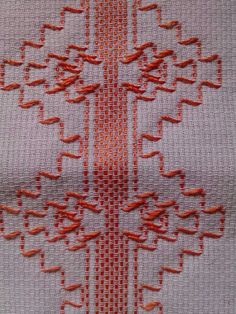 an orange and white piece of cloth with designs on it