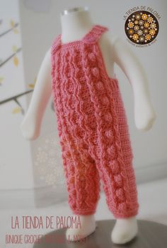 the doll is wearing a pink knitted outfit