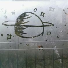 an image of a space shuttle drawn on the window glass in front of a gate