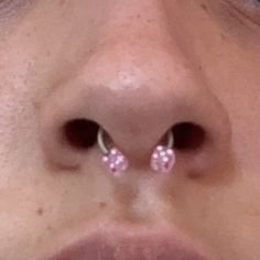 a woman's nose with two piercings on it