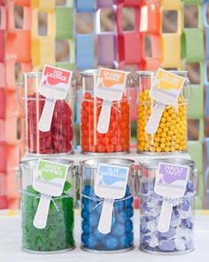 colorful candies in plastic containers with labels on them