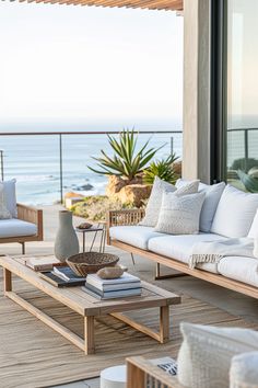 an outdoor living room with white furniture and ocean view