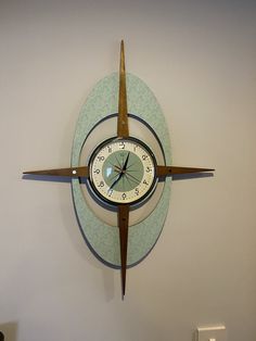 a clock mounted to the side of a wall with an arrow on it's face