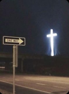 a street sign with a cross on it at night