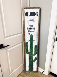 a welcome sign in front of a door with a cactus painted on it and the words welcome to each other