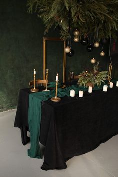 the table is set with candles and greenery