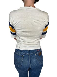 Step up your game(day)! This awesome authentic vintage San Diego Chargers can bring back to the memories of when they were a San Diego based team. With a v-neck collar, massive wordmark graphic, and striped short sleeves, this jersey cut t-shirt has it all! Iconic 70s slim fit that will tuck gorgeously into jeans. Product Measurements: See the Measurement Guide in the photo carousel. Shoulder: 16" Chest: 32" Sleeve Length: 10.5" Entire Length: 25" Condition: B See the Condition Grade Scale on th Vintage White V-neck Top, 90s Style Cotton Top For Game Day, Vintage Cotton Tops For Game Day, Vintage Cotton V-neck T-shirt, Casual V-neck Tops For Fan Merchandise, Retro White Tops For Game Day, Retro Cotton V-neck Tops, Vintage Cotton Tops For Sports Events, Retro Crew Neck Tops For Game Day