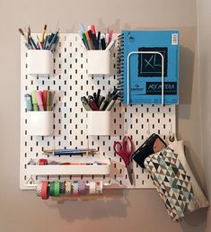 the pegboard is organized with pens, pencils, scissors and other office supplies