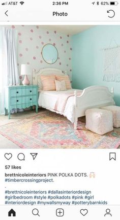 a bedroom with pink polka dots on the wall and blue dressers in the corner