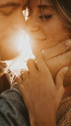 a man and woman kissing each other with the sun shining through their eyes behind them