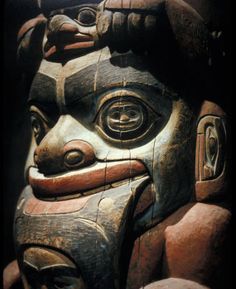 a close up of a wooden statue with many carvings on it's face and hands