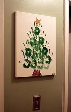 a handprinted christmas tree hanging on the wall