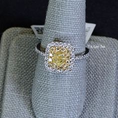 a yellow diamond ring sitting on top of a cloth