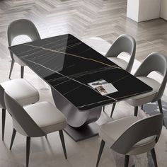 a dining table with chairs around it and a magazine on the table next to it