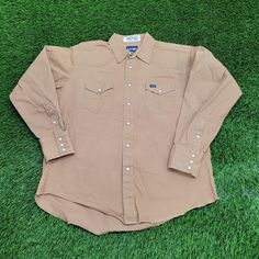 Vintage Wrangler Western Pearl-Snap Shirt XL 25x31 Brown Step into classic Western style with this vintage Wrangler pearl-snap button shirt in brown, perfect for XL size.  * Used condition  * No rips/holes  * No stains  * Normal fading from washing VINTAGE WRANGLER SHIRT, PEARL SNAP BUTTON SHIRT, VINTAGE WESTERN SHIRT, WRANGLER PEARL SNAP, XL WESTERN SHIRT, BROWN VINTAGE SHIRT, 25X31 VINTAGE SHIRT, RETRO WRANGLER SHIRT, WESTERN FASHION, VINTAGE COWBOY SHIRT 74079 Western Brown Tops With Buttons, Western Style Brown Tops With Buttons, Brown Western Top With Buttons, Brown Western Style Top With Buttons, Western Brown Collared Tops, Western Style Brown Collared Top, Western Brown Tops With Snap Buttons, Long Sleeve Brown Shirt For Ranch, Western Snap Button-up Shirt